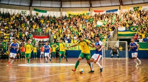 Partido de futsal en un pabellón brasileño con ambiente vibrante y público animado