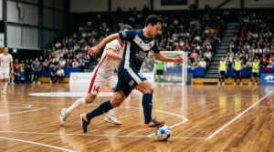 Jugador de fútbol sala controlando el balón durante un partido en pabellón iluminado